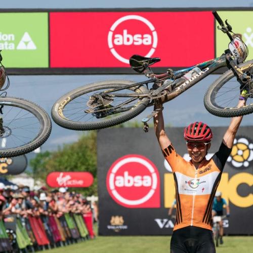 Annika Langvad and partner holding their bikes over their head [Swiss Epic]