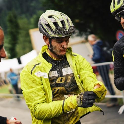 A biker covered in mud adjusting his sleeve [Swiss Epic]