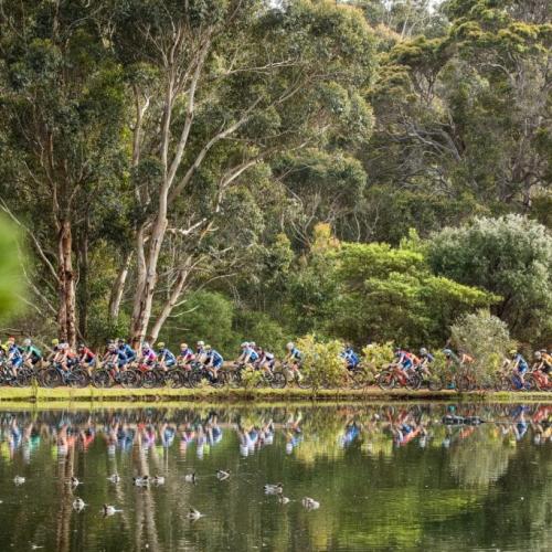 Hundreds of bikers heading across a path near a lake [Cape to Cape]