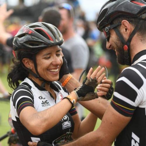 Two bikers holding hands crossing the finish line [Swiss Epic]
