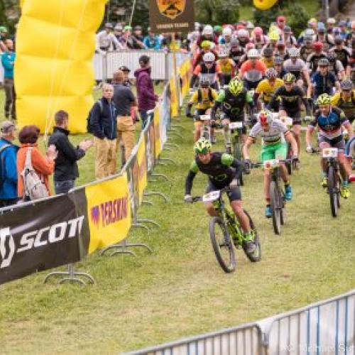 A league of bikers heading through the grassy Perskindol race  [Swiss Epic]