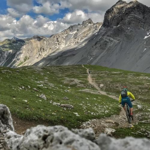Stefan Wolfisberg biking through a valley [Swiss Epic]