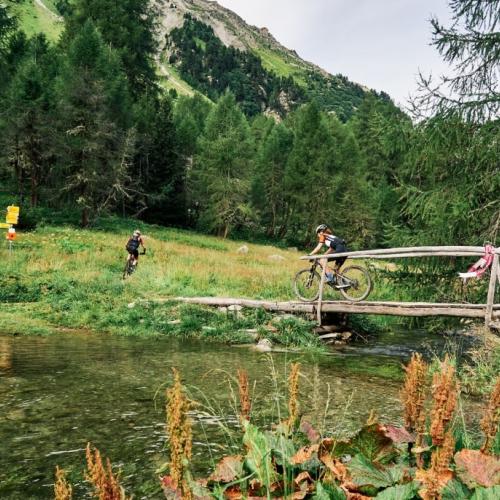 Two bikers heading over a bridge on the Graubunden race [Swiss Epic]