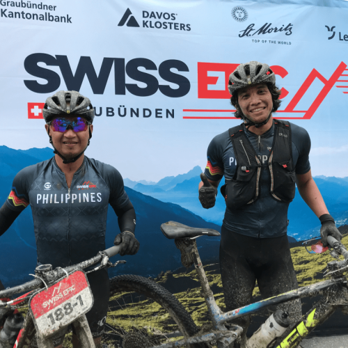 Two of the Phillipines team posing in front of the Swiss Epic poster post race [Swiss Epic]