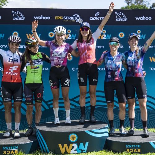 Elite women’s podium after Stage 1 of the 2025 FNB Wines2Whales Chardonnay (from left to right): Margot Moschetti, Claudia Peretti, Tyler Jacobs, Candice Lill, Robyn de Groot, and Sarah Hill. Photo by Dom Barnardt. 